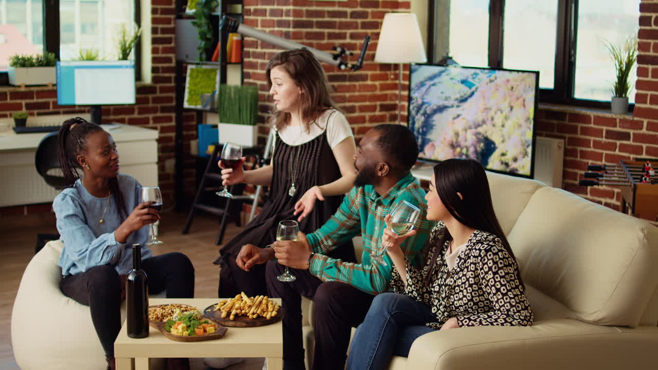 Friends listening to funny tale from host while drinking wine and eating snacks