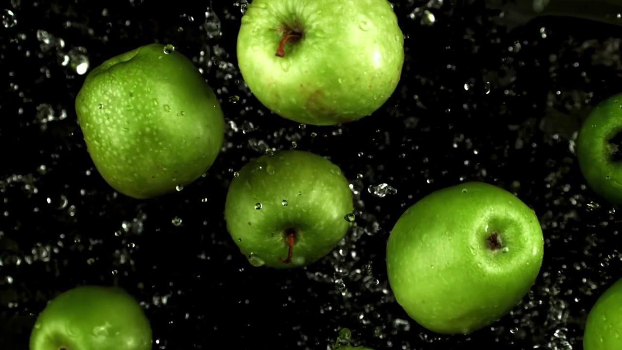 Rallentatore di mele verdi fresche che schizzano nell'acqua