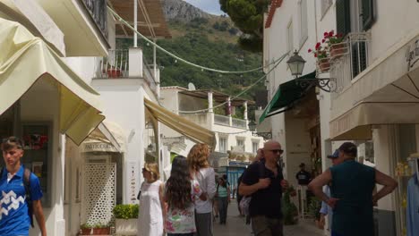 tourists wander anacapri's busy, white-architecture streets on a bright summer day