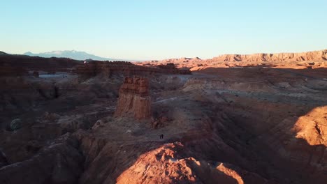 Órbita-Aérea-Alrededor-De-Personas-Caminando-En-El-Parque-Estatal-Goblin-Valley