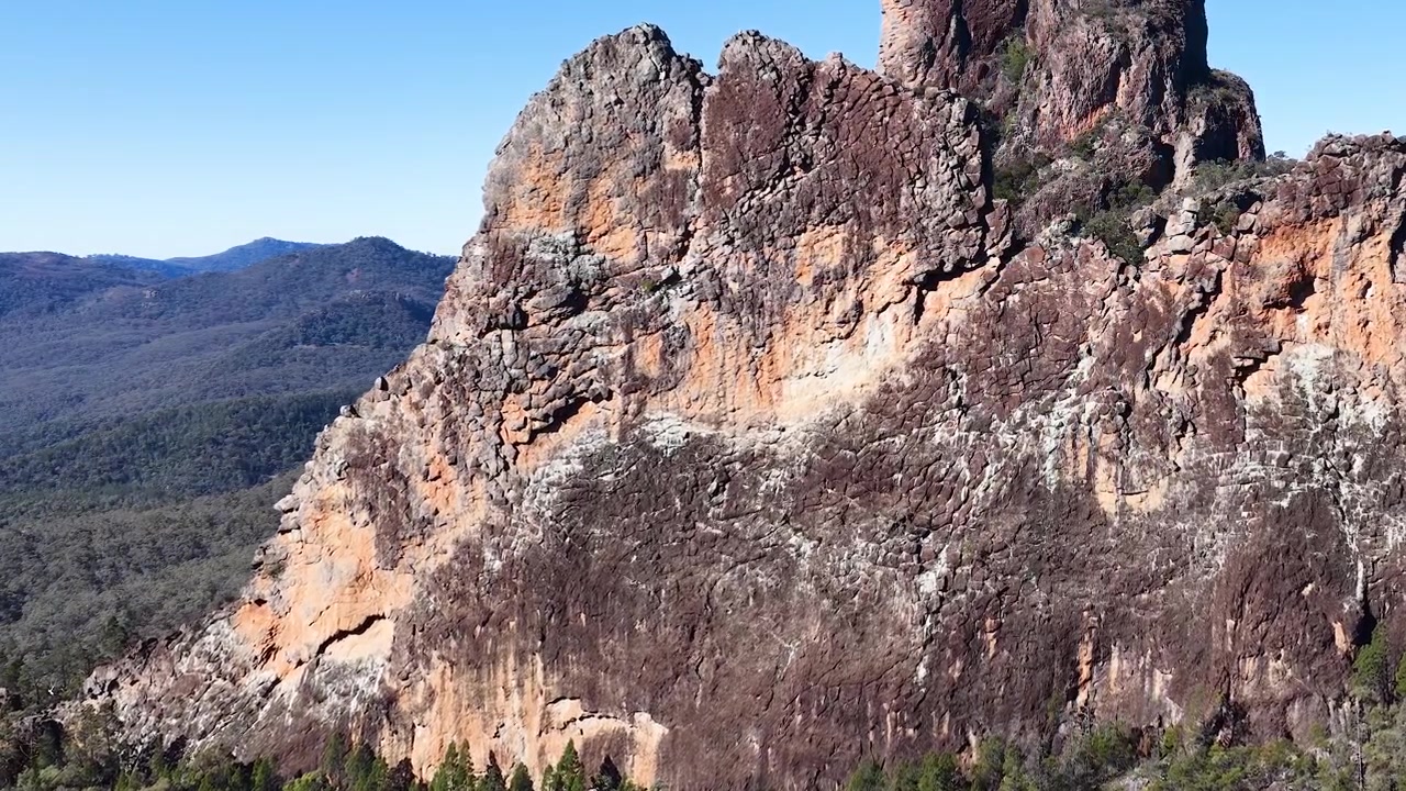 Weitwinkelaufnahme von alten Vulkangipfeln und Klippen unter klarem blauem Himmel in Australien