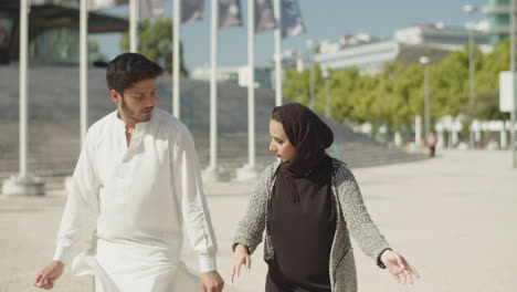 young muslim couple performing traditional dance on sunny day.