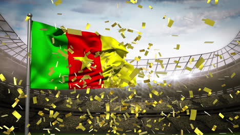 confeti dorado cayendo sobre la bandera de camerún contra el estadio deportivo en el fondo