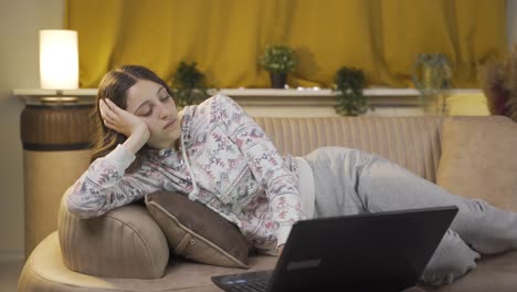 young woman getting tired while using computer at night.