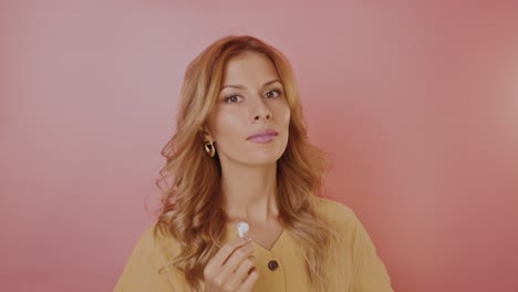 Woman with Earbuds in Front of Pink Background