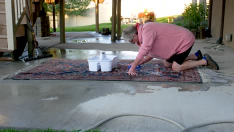 Hand-scrubbing-an-oriental-or-Persian-carpet-with-soap-and-water---medium,-static-shot