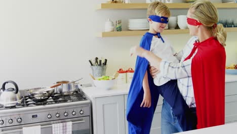 mother and son pretending to be superhero in living room 4k