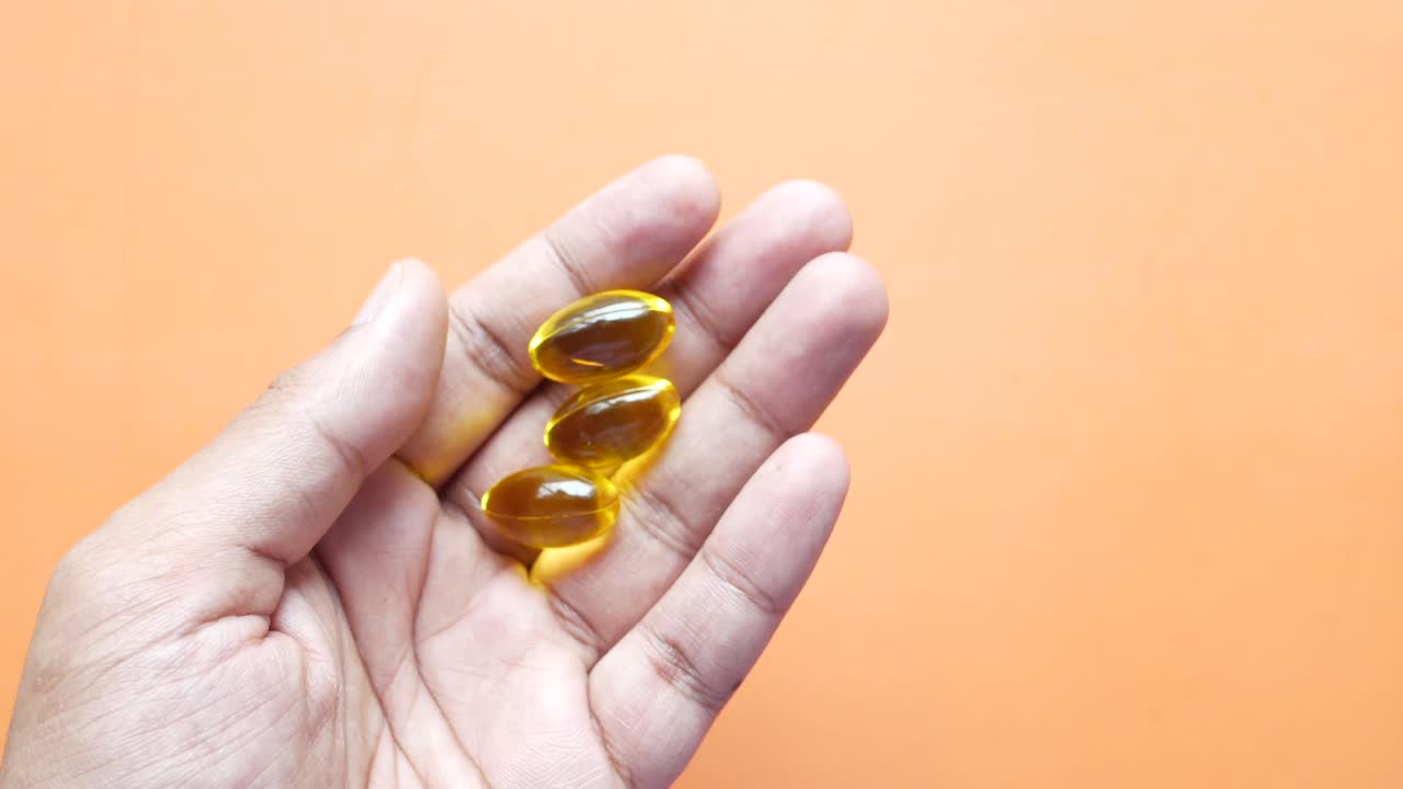 con las cápsulas amarillas en la mano