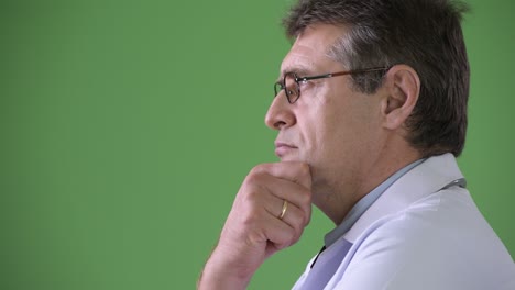 mature handsome man doctor against green background