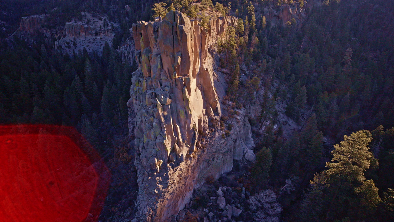 Drone view of jagged cliffs canyon valley Los Alamos NM arid desert terrain aerial landscape footage