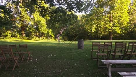 Dolly-out-shot-of-diamond-arch-with-flowers-revealing-chairs-for-outdoor-wedding