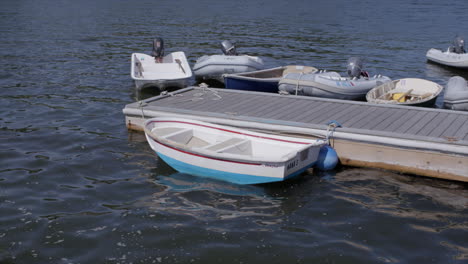 a dinghy and other boats in gentle waves at the lake in cape cod