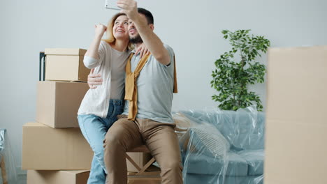 una pareja tomando selfies durante una mudanza de casa
