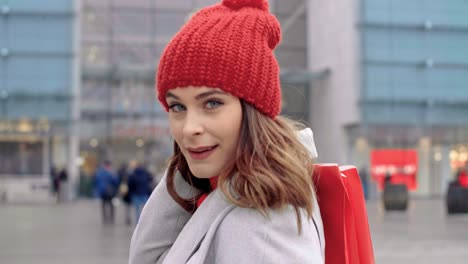 Rear-view-of-woman-with-shopping-bags-in-the-city-street