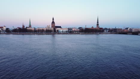 aerial opening shot of latvian capital city riga, dolly in over river daugava