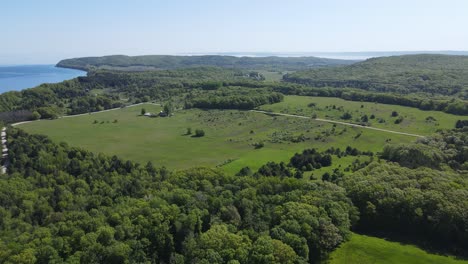 farmland and woodland near shoreline of michigan lake, aerial view