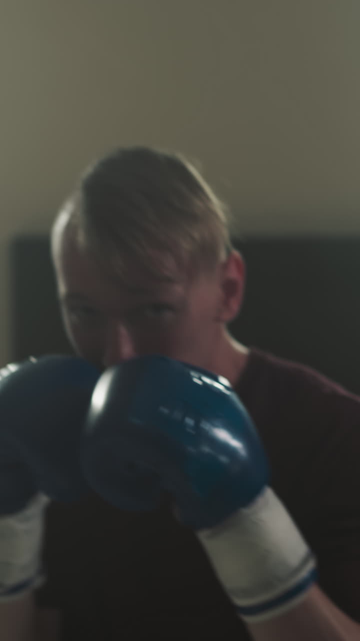 el atleta muestra ganchos y uppercuts entrenando en un club deportivo. el boxeador profesional entrena puñetazos ante la cámara en el gimnasio en cámara lenta. ejercicios de artes marciales