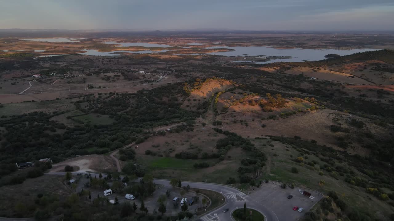 drone volando sobre el pueblo de monsaraz con el río alqueva en el fondo al atardecer, portugal