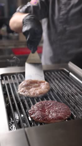 chef cooking hamburgers on a grill