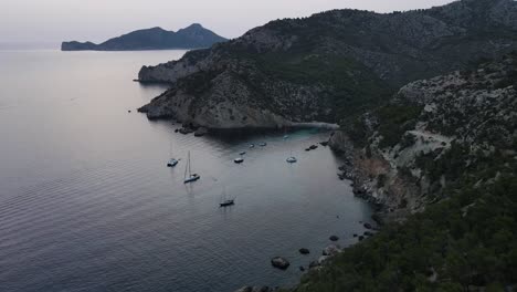 Drohnenansicht-Von-Klippen-Und-Blick-Auf-Segelboote,-Die-Am-Strand-Von-Cala-D&#39;egos,-Spanien,-Angedockt-Sind