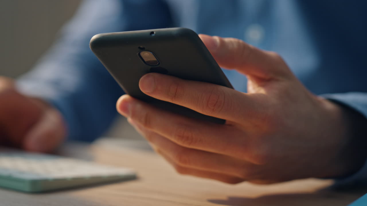 Mani di startupper che digitano sulla tastiera, primo piano sulla scrivania dell'ufficio. Uomo che risponde a una telefonata.