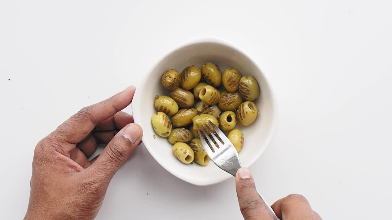 aceitunas verdes en un cuenco con tenedor