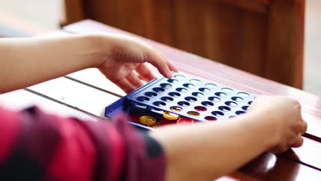 two people playing connect four on a table