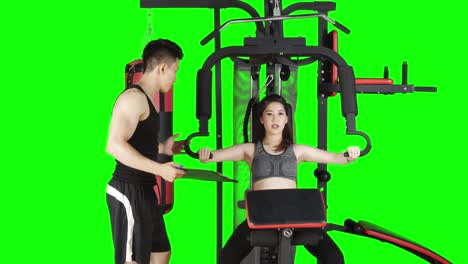 woman exercising with personal trainer at gym