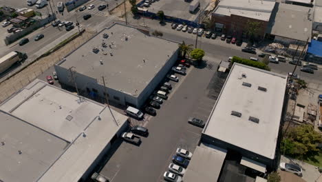rising tilt down aerial above industrial parking lot next to highway
