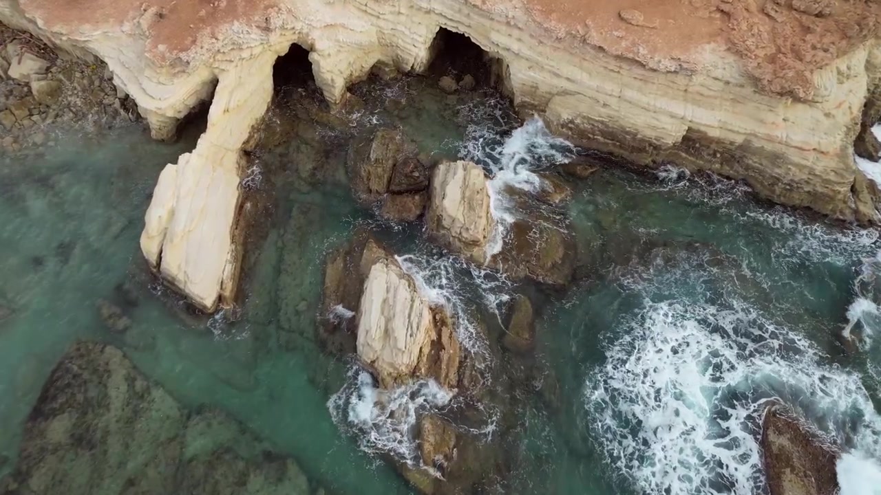 Breathtaking aerial view of Peyia Sea Caves in Paphos, Cyprus, showcasing the dramatic coastline and mesmerizing rock formations against the turquoise sea.