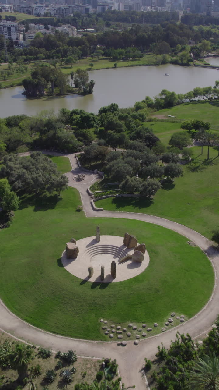 Vertical video tilt down from tel aviv skyline to the stone garden in the Yarkon Park