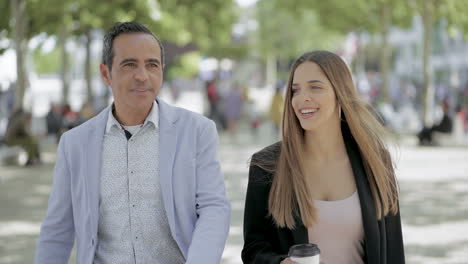 felices colegas masculinos y femeninos hablando al aire libre