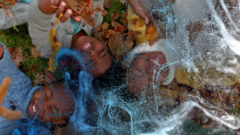 family lying head-to-head on autumn leaves, swirling digital particles enhancing technology concept
