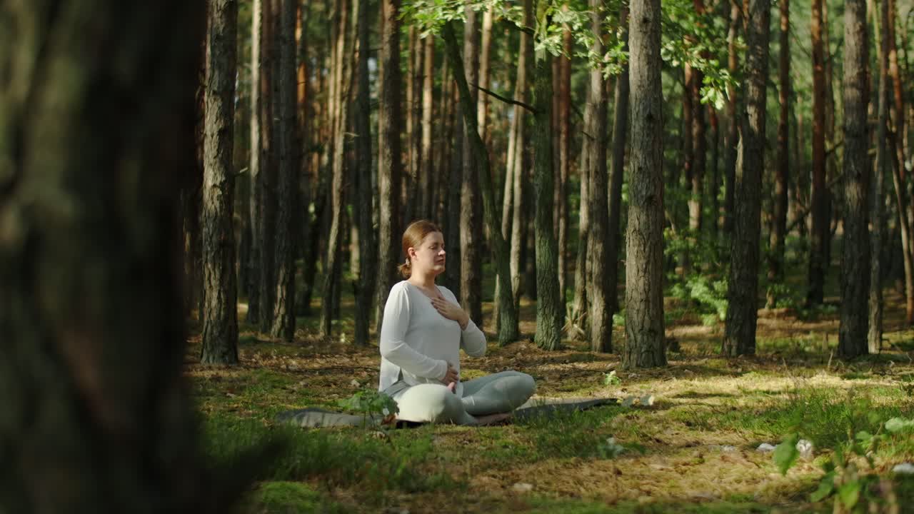 Woman practicing yoga and meditation in a forest