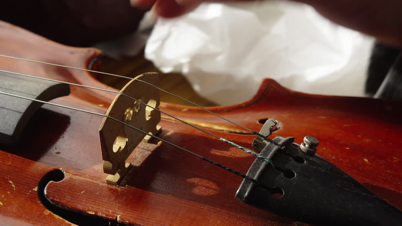 Musical Craftsman adjusts maple wood bridge tension for violin strings