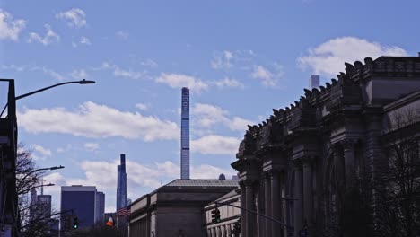 new york’s metropolitan museum lines fifth avenue as modern skyscrapers rise behind, blending history, culture, and vertical ambition under a crisp blue sky