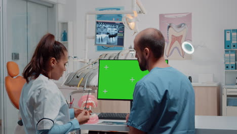 Mujer-Dentista-Y-Hombre-Trabajando-Con-Pantalla-Verde-En-El-Monitor