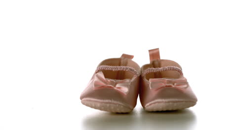 baby shoes falling and bouncing on white surface