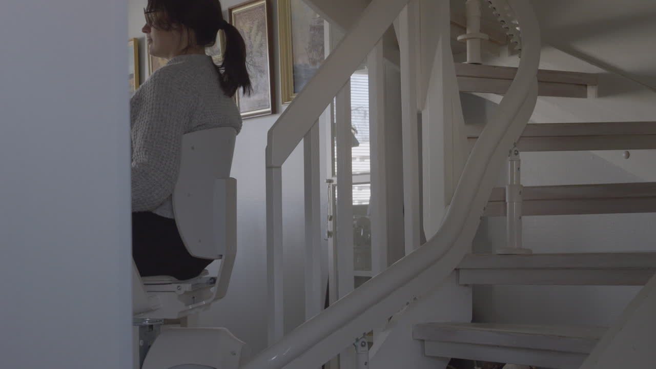 Disabled woman climbing house stairs with rail stairlift