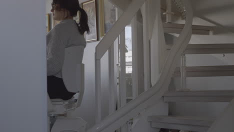 disabled woman climbing house stairs with rail stairlift