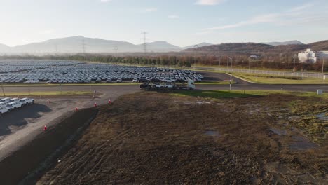 aerial - car carrier trailer with loaded vehicles leave manufacturing territory