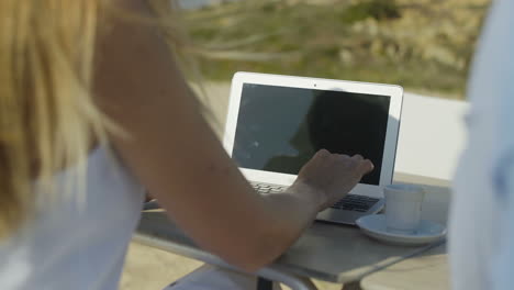 foto recortada de una mujer usando una computadora portátil al aire libre