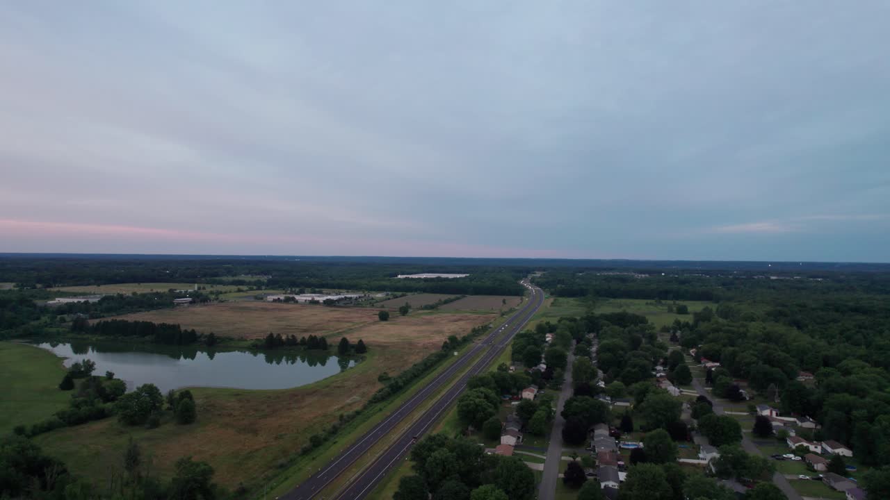 vista aérea de una hermosa puesta de sol, carretera ocupada con árboles a ambos lados
