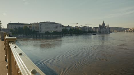 flooded riverside walkway along the danube with the hungarian parliament in the distance during budapest flood 2024