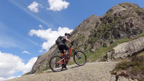 uphill mountain bike trail ridig on a big rock with a mtb amazing mountain landscape view in the austrian alps