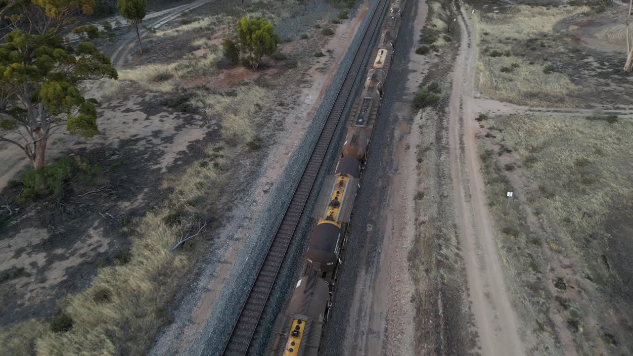 drone volando sobre el tren de carga de combustible que pasa en el paisaje rural, australia occidental
