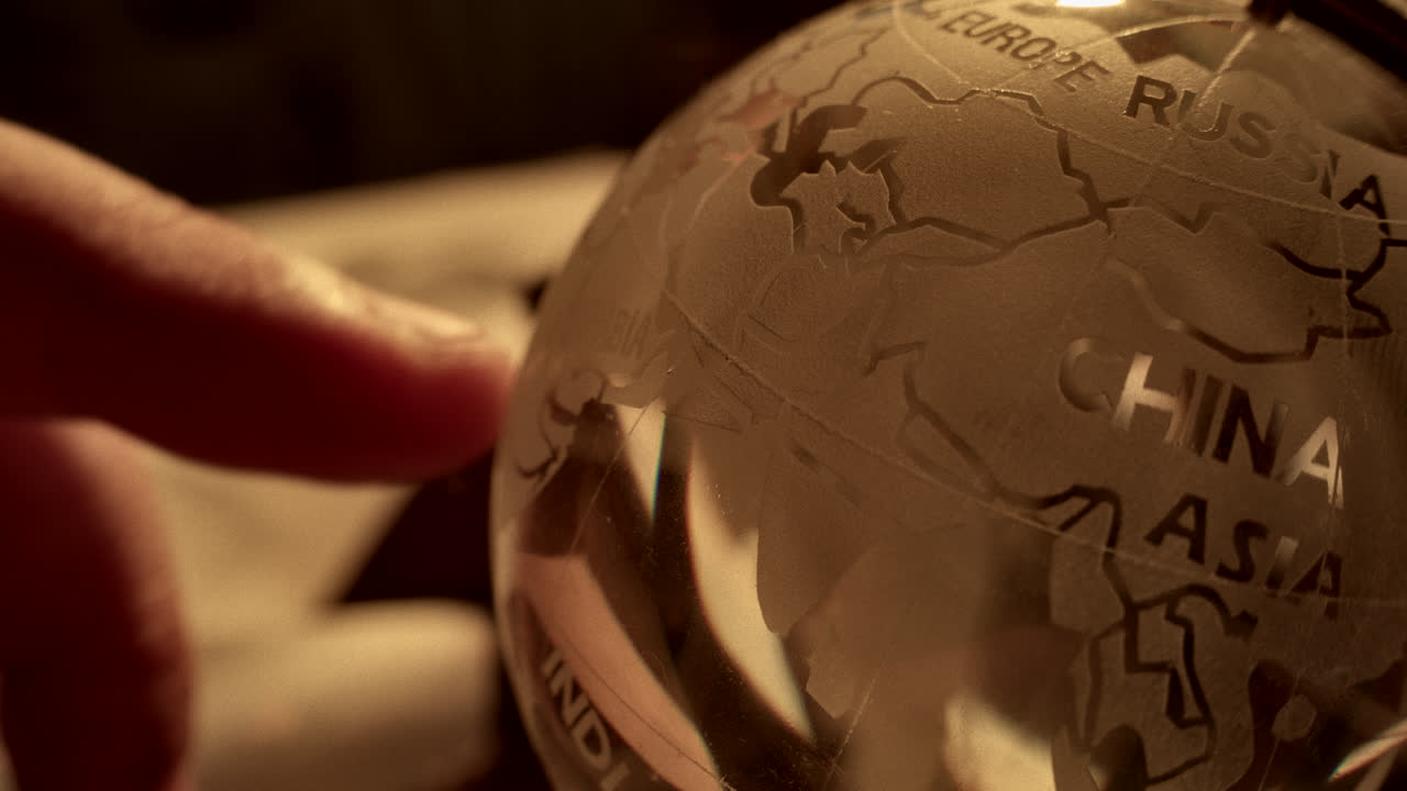 Person Pointing at a Glass Globe