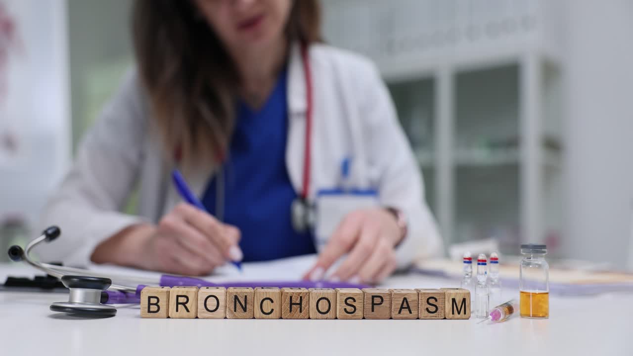 Parola "Broncospasmo" su cubi con medico che lavora sullo sfondo