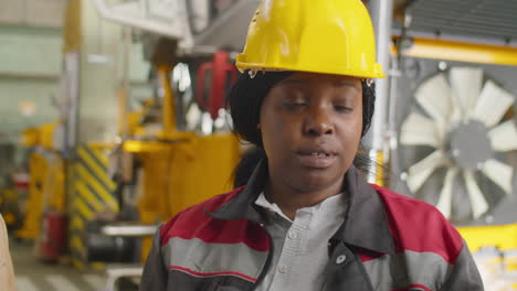 female engineer speaking with managers in industrial plant