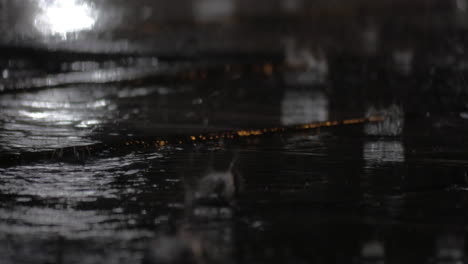 rain and puddles on sidewalk at night